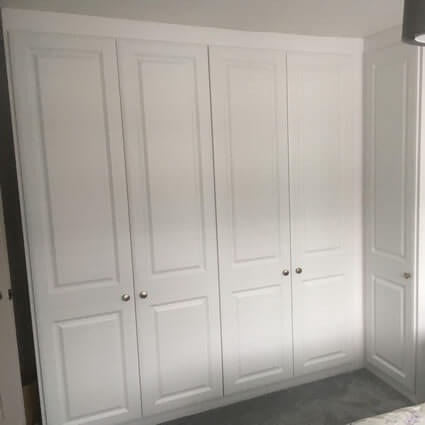 Corner wardrobe in Satin White with York style doors.